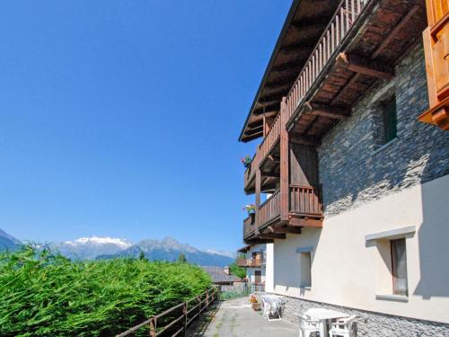 a building with a balcony and mountains in the background at Apartment Grand Sarriod-1 by Interhome in Saint Nicolas