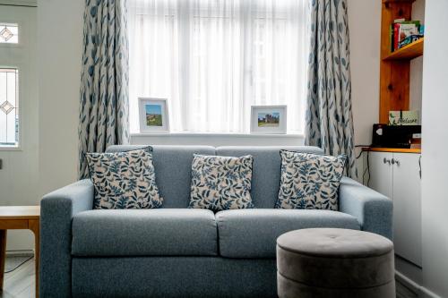 a blue couch in a living room with a window at Cottage in Ludlow in Ludlow