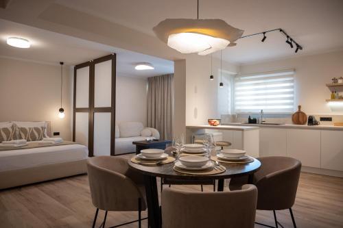 Una cocina y una sala de estar con mesa y sillas. en Chrysa's Deluxe Apt, en Nauplia