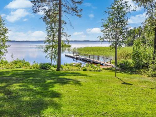 un quai sur un lac avec une pelouse verte dans l'établissement Holiday Home Piilopirtti by Interhome, à Salonnenä