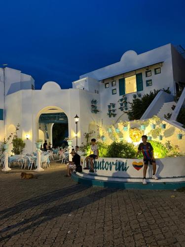 a group of people sitting on a wall in front of a building at Plaza Blanca in Doradal