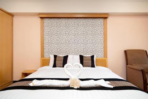 a bedroom with a large bed with a white bow on it at P-Park Hotel Bangkok in Bangkok