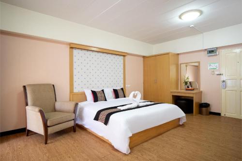 a bedroom with a large white bed and a chair at P-Park Hotel Bangkok in Bangkok