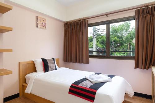 a bedroom with two beds and a window at P-Park Hotel Bangkok in Bangkok