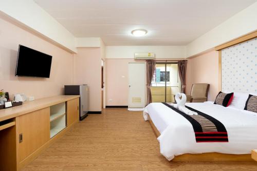a hotel room with a bed and a flat screen tv at P-Park Hotel Bangkok in Bangkok