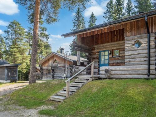 eine Blockhütte mit Treppe zum Vordereingang in der Unterkunft Holiday Home Vuokatinportti a 11 by Interhome in Lahdenperä