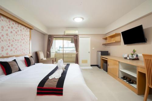 a hotel room with a bed and a television at P-Park Hotel Bangkok in Bangkok