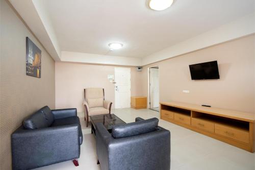 a living room with two couches and a tv at P-Park Hotel Bangkok in Bangkok