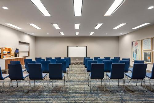 a conference room with blue chairs and a whiteboard at Holiday Inn Express Morgantown by IHG in Morgantown