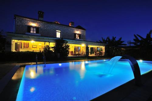 a swimming pool in front of a house at night at Alacati Koclu Konagi Hotel in Alacati