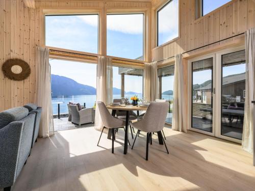 a dining room with a table and chairs and large windows at Holiday Home Hildebu by Interhome in Sørbø