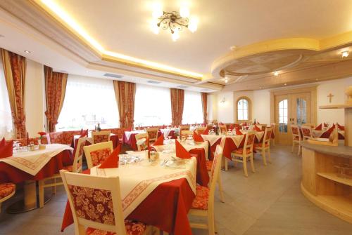Hotel L'Ideale في موينا: مطعم فيه طاولات وكراسي في الغرفة