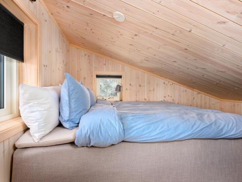 a bed in a room with a wooden ceiling at Holiday Home Hildebu by Interhome in Sørbø