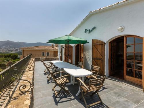 a table and chairs with an umbrella on a patio at Villa Les Oliveres by Interhome in Llança