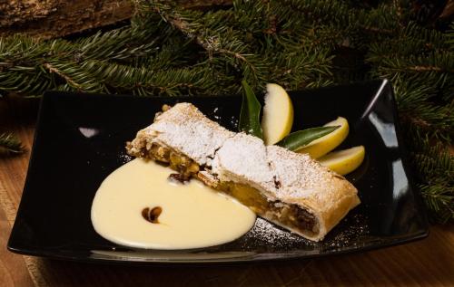 a piece of cake and apples on a black plate at Hotel Pedranzini in Santa Caterina Valfurva
