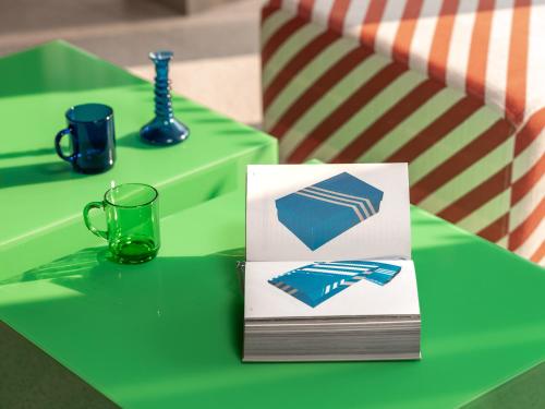 a green table with a cup and a card on it at Hôtel Vertime in Les Sables-dʼOlonne