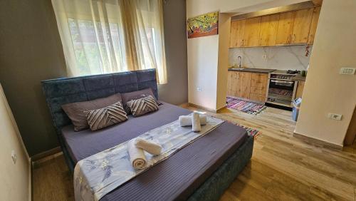 duże łóżko w pokoju z kuchnią w obiekcie Dua's Apartment w Tiranie