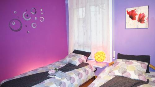 2 camas en una habitación con paredes rosas y moradas en Manuela Beach City, en Lloret de Mar
