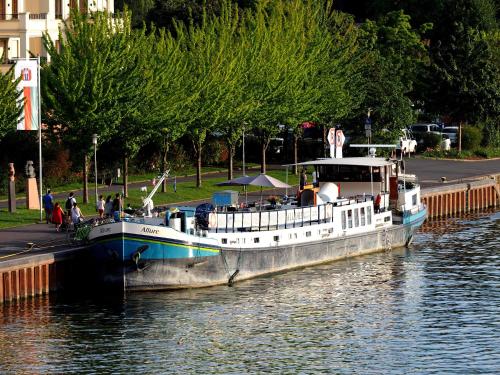 un bateau est amarré à un quai dans l'eau dans l'établissement Hotelboat Allure, à Amsterdam