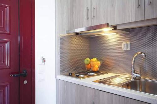 a kitchen with a sink and a bowl of apples at Orfeas Studios Molivos in Mithymna