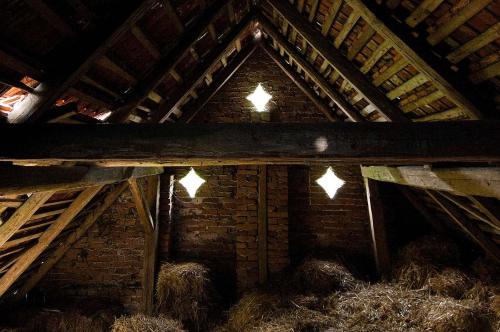 a barn with hay and lights in the ceiling at Historický zemědělský dvůr Kladeruby in Hustopeče Nad Bečvou