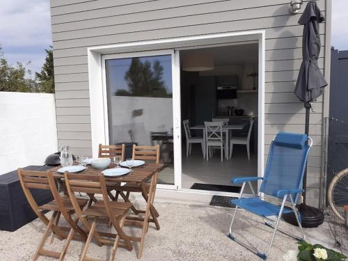 a wooden table and chairs on a patio at Succom'baie au cottage de la Maye in Le Crotoy