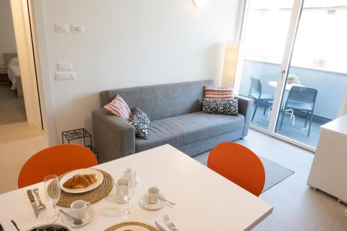 a living room with a couch and a table and chairs at Civetta BLU, Blue Owl Apartments in Trento