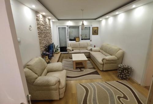 a living room with two couches and a table at Apartman Emilija i Julija in Soko Banja
