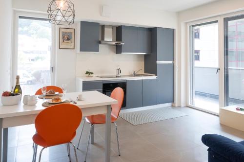 a kitchen with orange chairs and a white table at Civetta BLU, Blue Owl Apartments in Trento