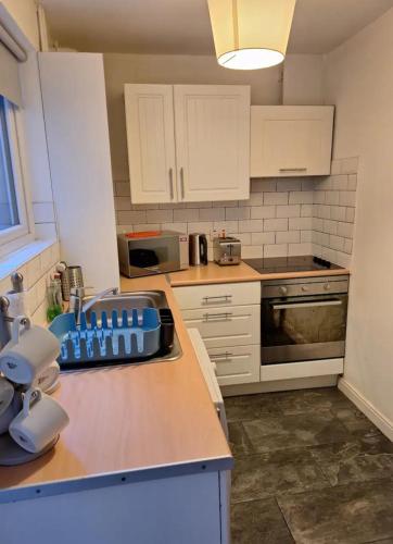 a kitchen with white cabinets and a counter top at Private Room on Donegall Road in Central Belfast in Belfast