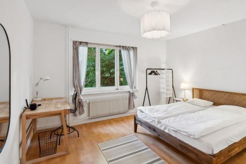 a bedroom with a bed and a desk and a window at Homey Comfort in Oerlikon in Zürich