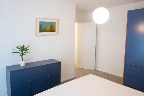a room with a blue cabinet and a potted plant at Civetta BLU, Blue Owl Apartments in Trento