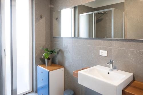 a bathroom with a sink and a mirror at Civetta BLU, Blue Owl Apartments in Trento