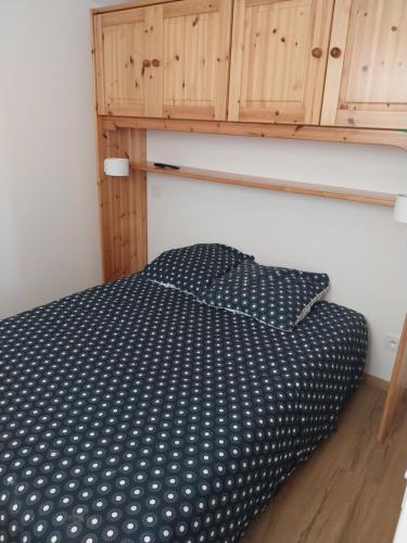 - un lit avec un oreiller à point de polka noir et blanc dans l'établissement Logement cabane à la ferme, à Sylvéréal