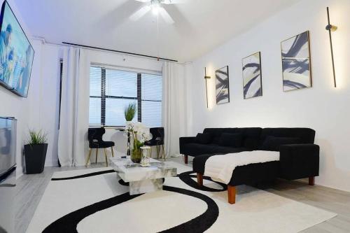 a living room with a black couch and a table at Luxe Skyrise Condo Downtown Jax in Jacksonville