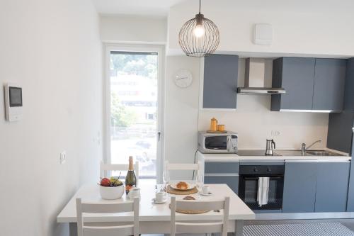a kitchen with blue cabinets and a table and chairs at Civetta BLU, Blue Owl Apartments in Trento