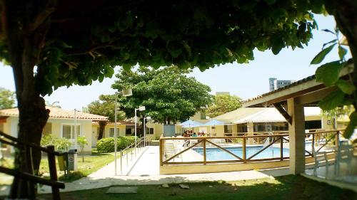 a pool with a wooden fence next to a house at Hotel Pousada do Sol in Aracaju