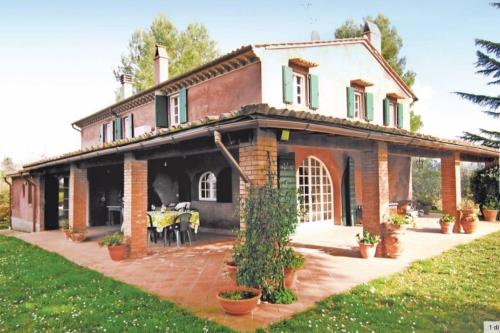a large brick house with a table in front of it at Tuscany country house, Poggio Vitale in Lorenzana