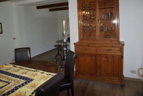 a dining room with a wooden cabinet and a table at Tuscany country house, Poggio Vitale in Lorenzana