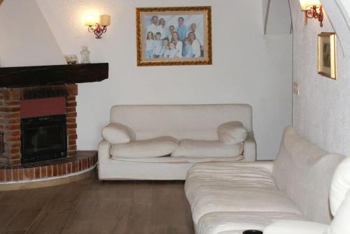a living room with two white couches and a fireplace at Tuscany country house, Poggio Vitale in Lorenzana