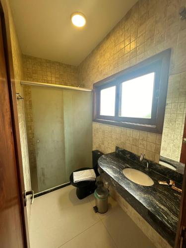 a bathroom with a sink and a shower at Pousada Porto da Barra in Barra Grande