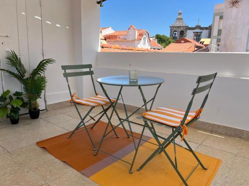 two chairs and a table on a balcony at Setubal Terrace apartments in Setúbal