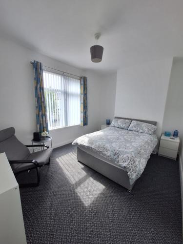 a bedroom with a bed and a chair and a window at Private Room on Donegall Road in Central Belfast in Belfast