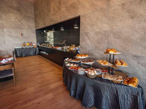 a buffet line with various types of bread and pastries at Galeria Plaza Leon in León