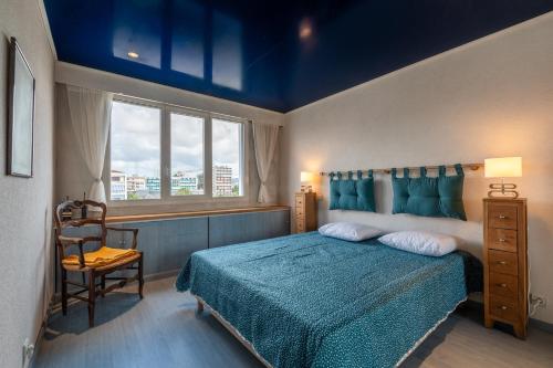 une chambre avec un lit, une chaise et une fenêtre dans l'établissement Grand appartement centre ville Annecy, à Annecy