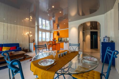 une salle à manger avec une table en verre et des chaises bleues dans l'établissement Grand appartement centre ville Annecy, à Annecy