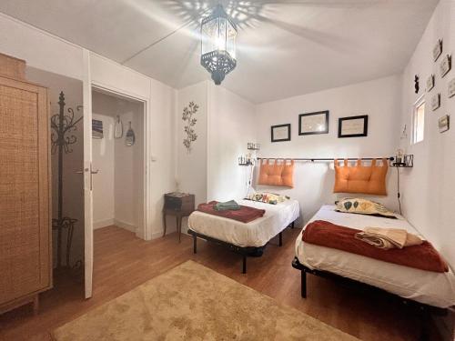 une chambre avec deux lits et un lustre dans l'établissement Appartement avec terrasse proche centre ville d'Arles, à Arles