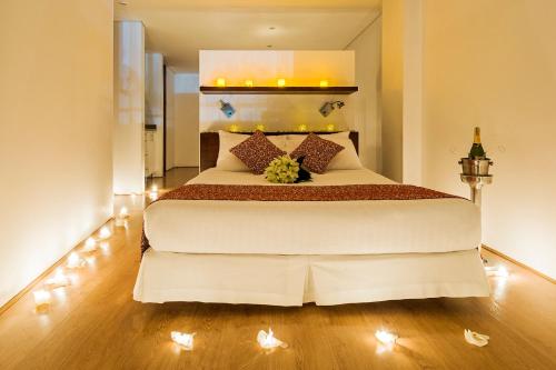a bedroom with a large white bed with lights at Hotel Hill House Usaquén in Bogotá