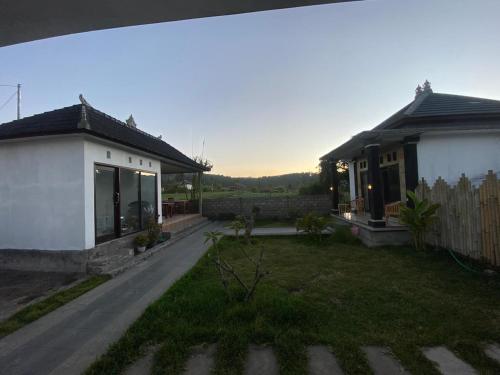 a house with a yard next to a building at Mount Batur Homestay in Kubupenlokan