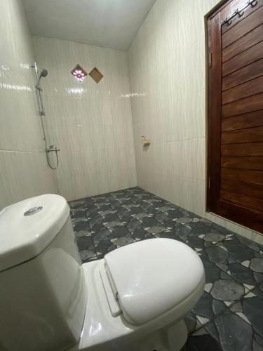a bathroom with a toilet and a shower at Mount Batur Homestay in Kubupenlokan